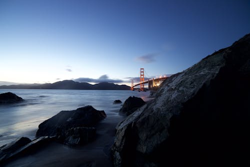 Black Rock Formation Near Red Concrete Bridge