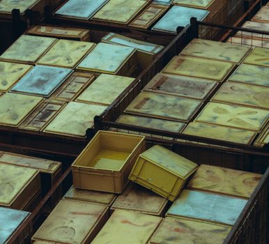 Overhead view of yellow and weathered plastic storage bins arranged neatly.