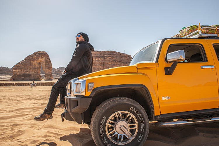 Man Sitting On A Yellow Hummer Car