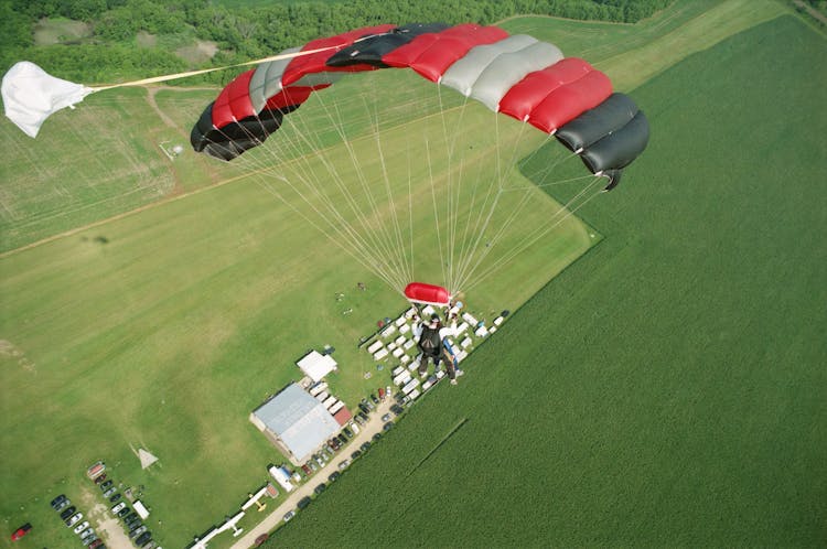 Photo Of A Man Parachuting Above A Field