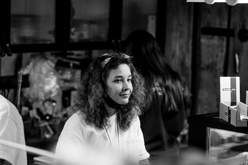 Free Young woman smiling indoors in a monochrome retail environment. Stock Photo