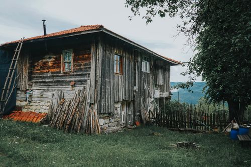 Free A rustic wooden house in rural Turkey with lush greenery and aged architecture. Stock Photo