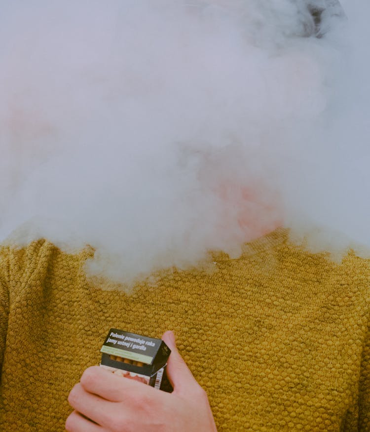 A Person Holding A Pack Of Cigarette