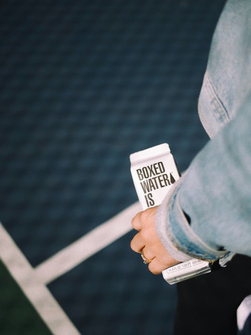 Hand Holding Carton of Water