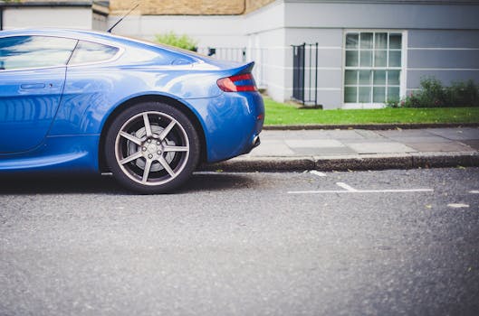 Blue sports car parked on a quiet urban street with a modern building backdrop.