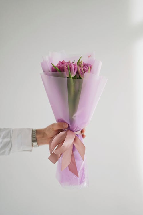 Free Unrecognizable Male Hand Holding Bunch of Pink Tulips Stock Photo