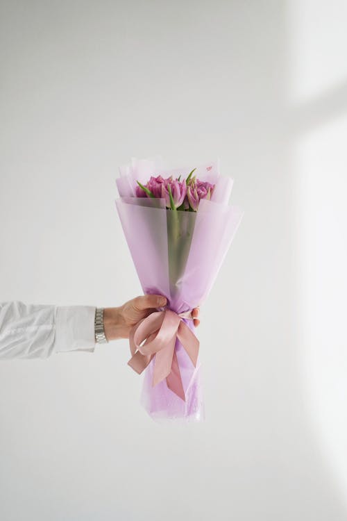 Hand Holding Bunch of Pink Flowers