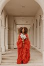 Woman in Red Peignoir Holding Bouquet