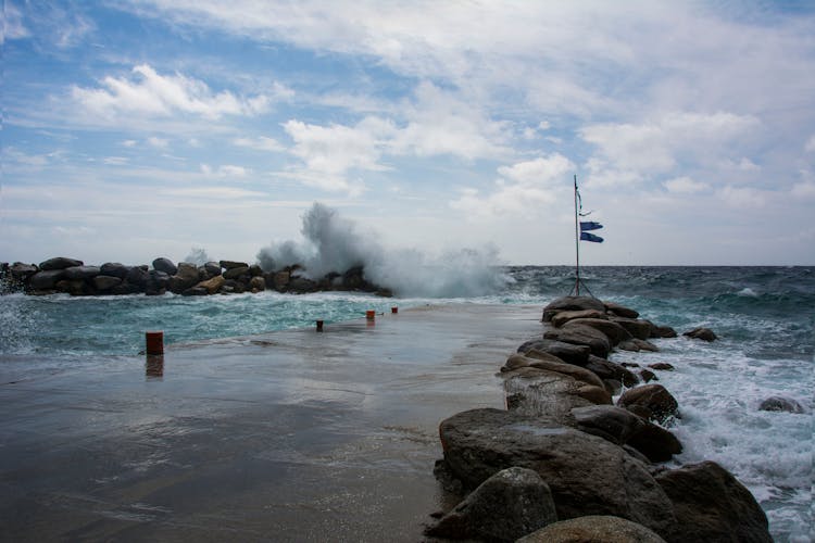 Pier With Stones And Storm On The Sea