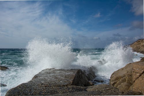 Rough Sea Waves with Foam and Rocky Coast