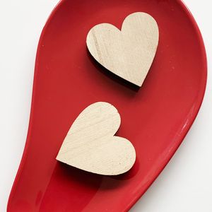 Two carved wooden hearts on a dish, photo by Lies on Pexels