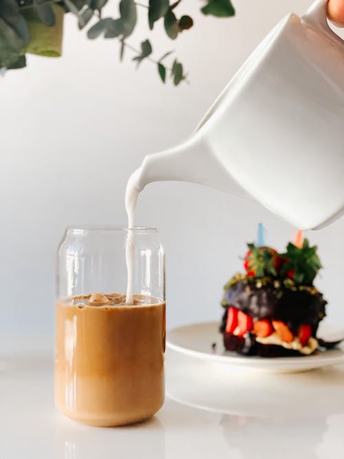 Free Person Pouring Milk into Iced Coffee Stock Photo