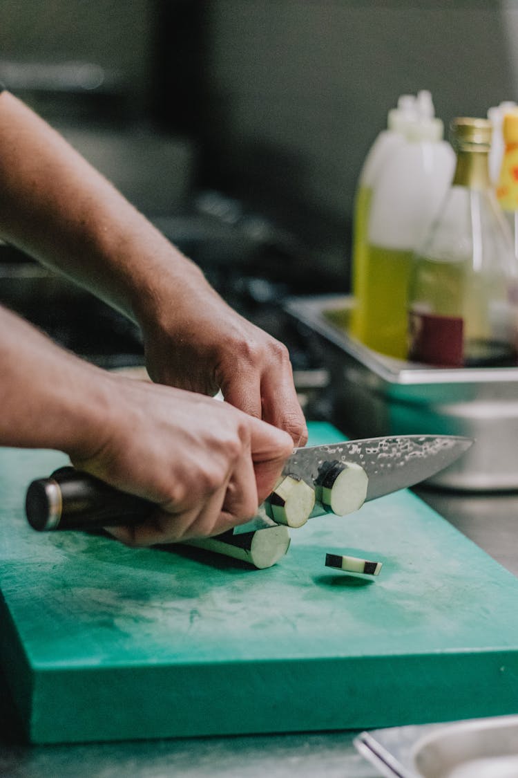 A Person Slicing A Cucumber 