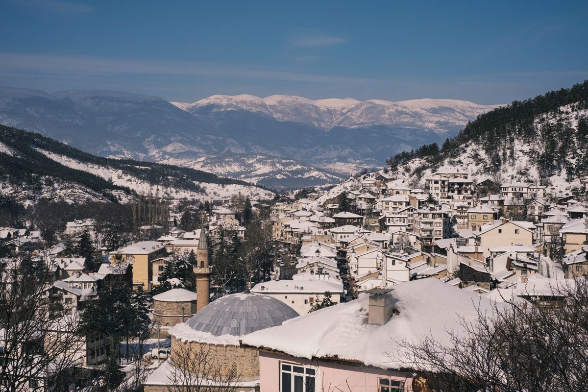 Peisaj montan cu un oraș într-o vale înzăpezită
