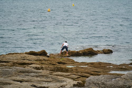 Free An Angler on the Beach Rocks Stock Photo