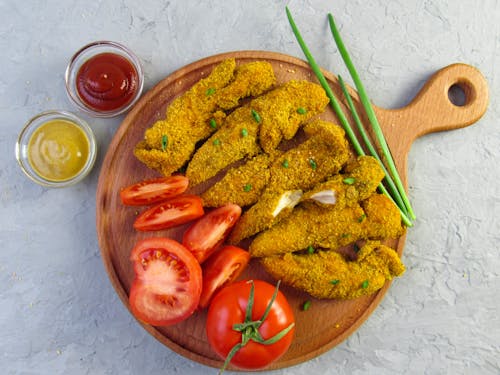 Chicken Fingers and Sliced Tomatoes Served on Wooden Tray