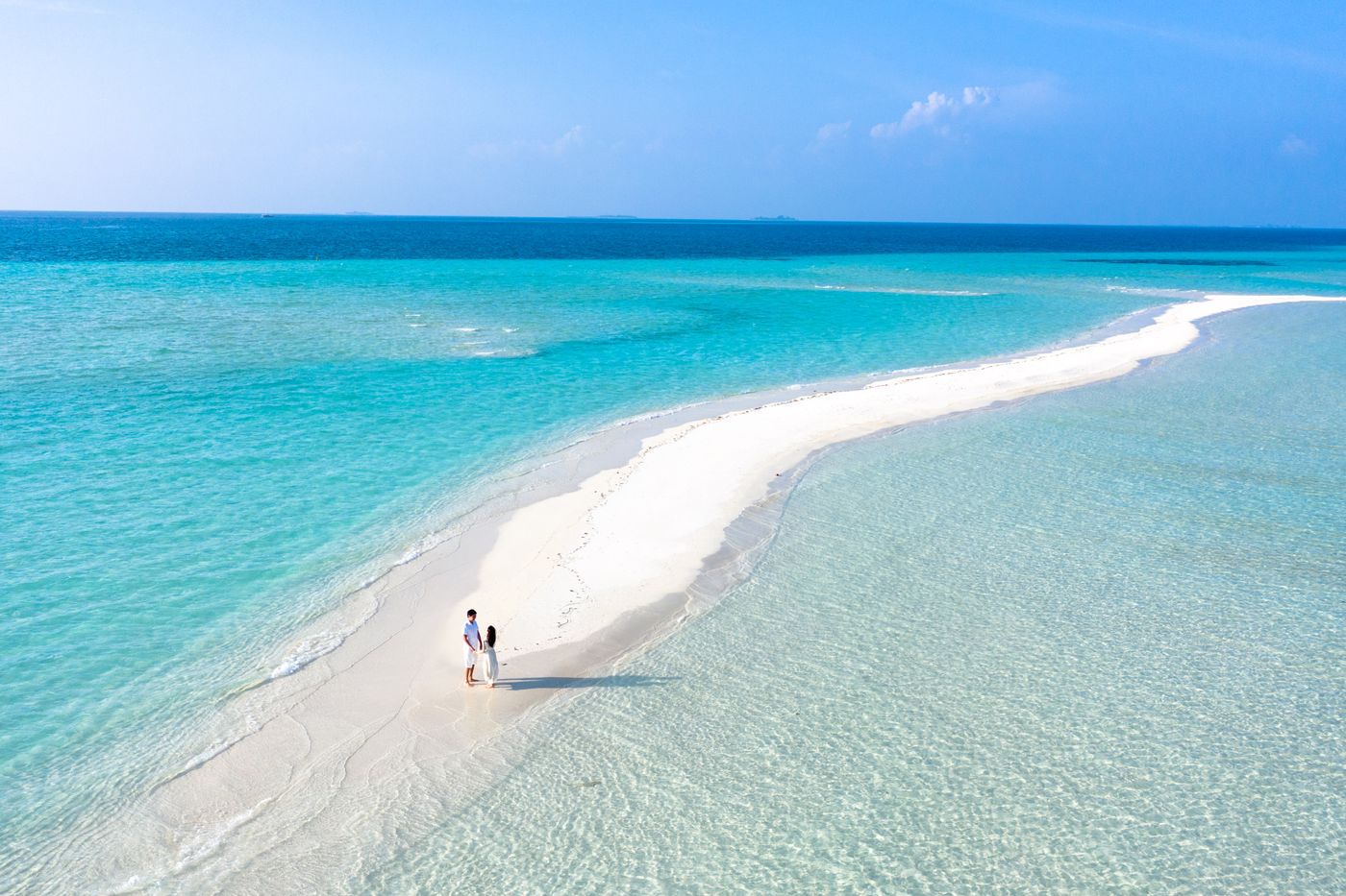 Pareja en una playa de arena clara y agua turquesa