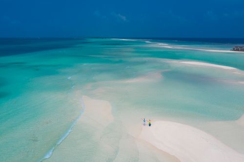 Free A stunning aerial view of a couple on a sandbar in Alifu Dhaalu Atoll, Maldives, with turquoise waters. Stock Photo