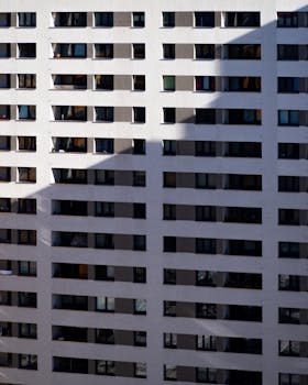 Contemporary apartment building facade in Berlin featuring repetitive windows and shadows.