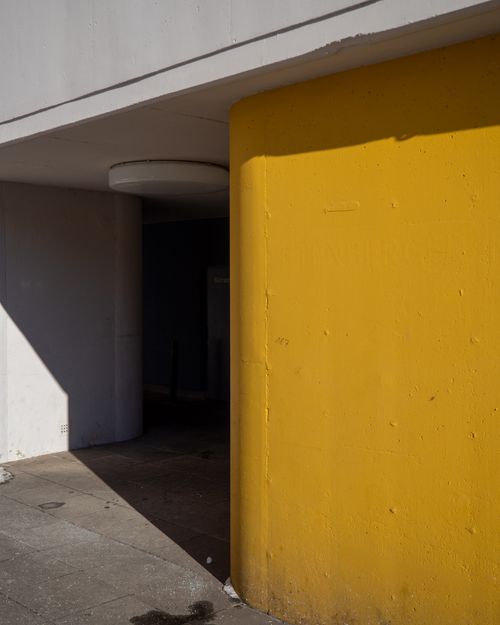 Free Stylish urban architecture with a vibrant yellow wall and minimalist design elements. Stock Photo