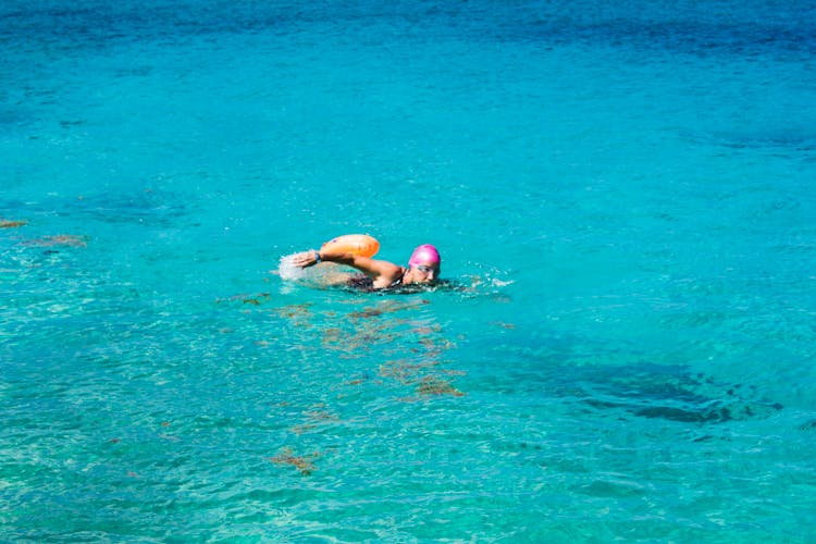 A Person Swimming In The Blue Water