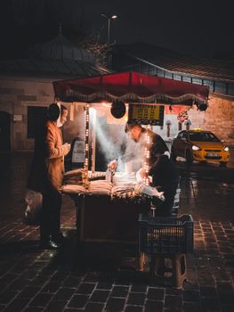 Captivating scene of a street vendor serving food at night in Istanbul, Turkey's vibrant streets.