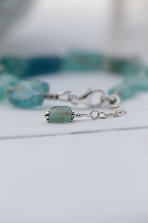 Free Close-up image of a handmade aquamarine beaded bracelet on a light surface. Stock Photo