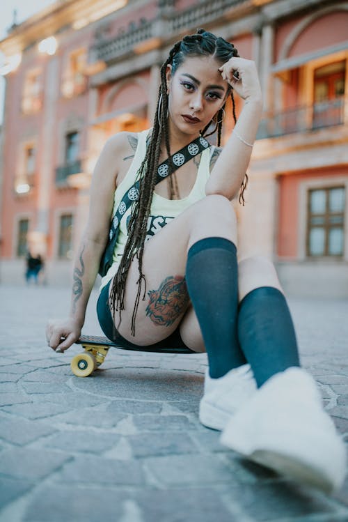 A Woman Sitting on a Skateboard
