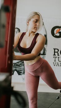 Adult woman working out with gym equipment in a modern indoor setting, showcasing fitness and active lifestyle.
