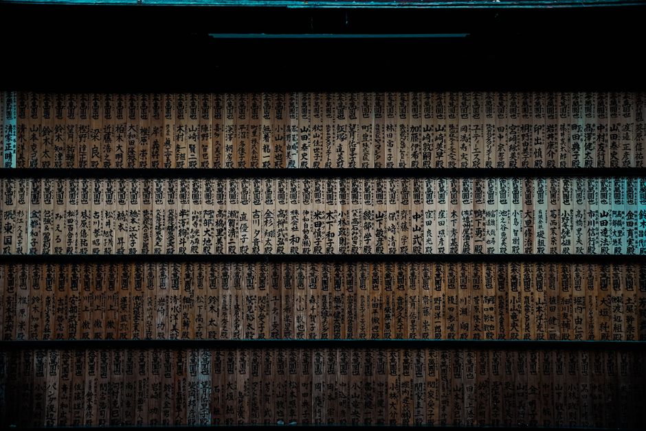 日本の神社にある漢字の書かれた木製の板のクローズアップで、伝統的なデザインを示しています。