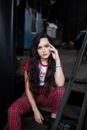 Woman in Red and Black Plaid Dress Shirt Sitting on Brown Wooden Bench
