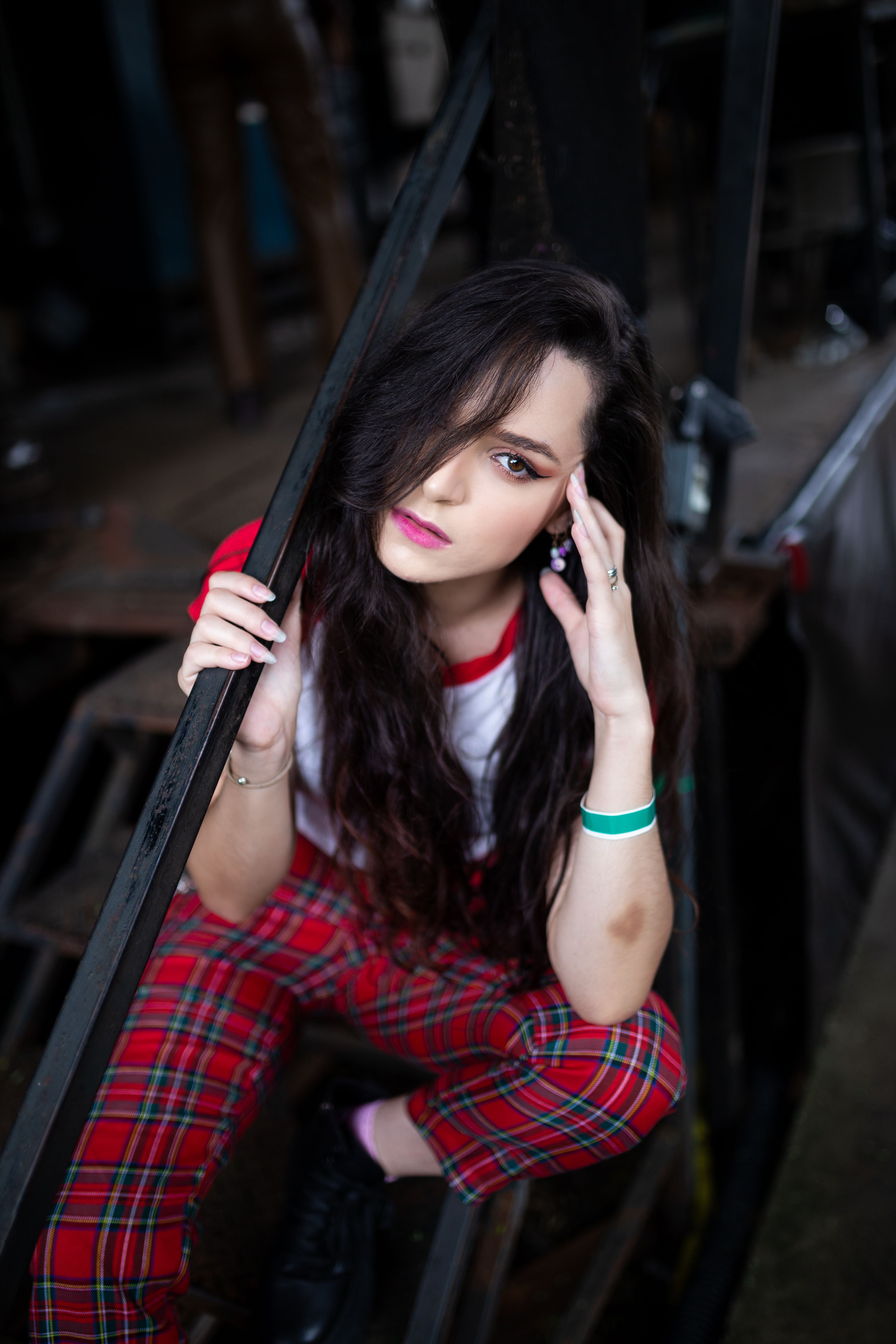 A Woman in Red and White Shirt Sitting on Metal Stairs · Free Stock Photo