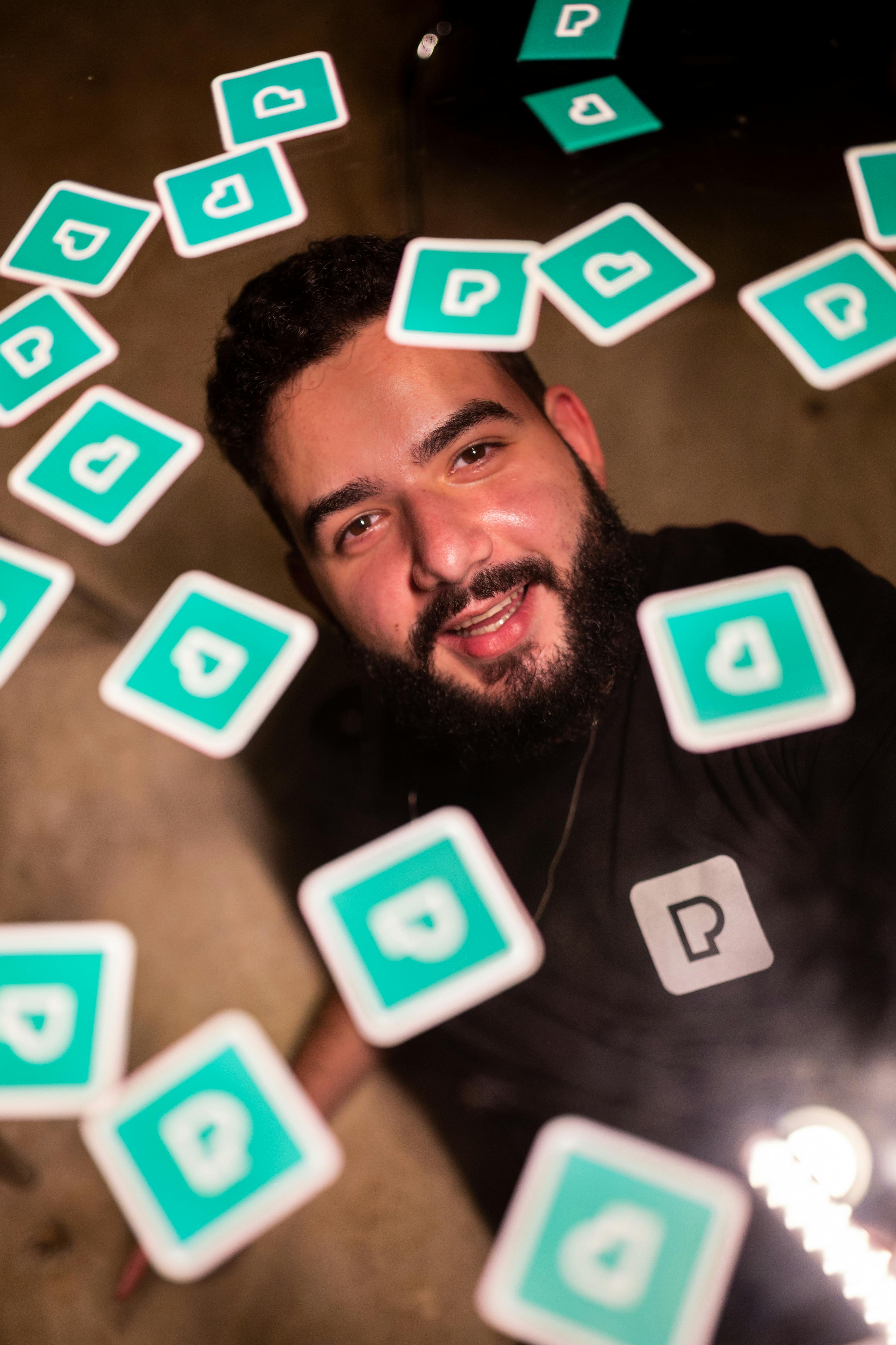 Portrait of a smiling man surrounded by floating cards in São Paulo, Brazil.