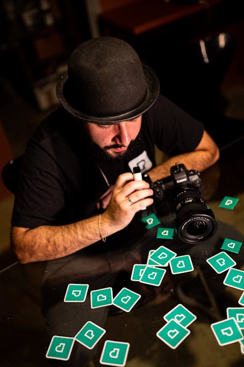 Foto profissional grátis de câmera dslr, chapéu preto, fotógrafo