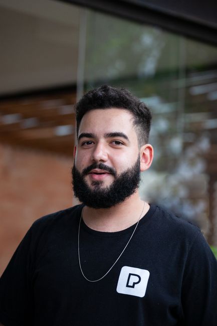 Fotomural Retrato de un joven con barba a la moda y collar de cadena, capturado al aire libre en São Paulo.