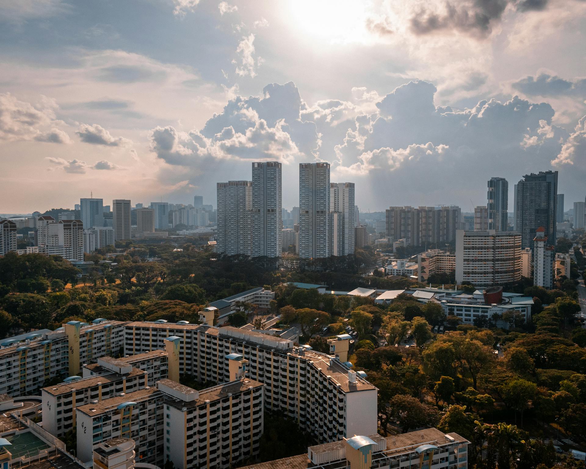 Stunning aerial view of Singapore cityscape showcasing high-rise buildings under a dramatic sky.