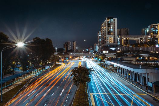 Stunning long exposure of Singapore's urban skyline at night with colorful light trails.
