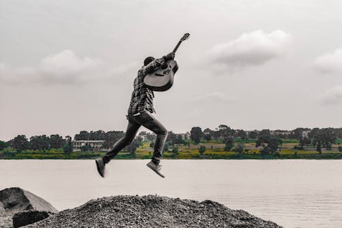 Free Man jumps with guitar Stock Photo