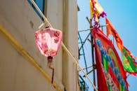 在白天，色彩缤纷的亚洲灯笼悬挂在充满活力的旗帜背景下，具有传统设计