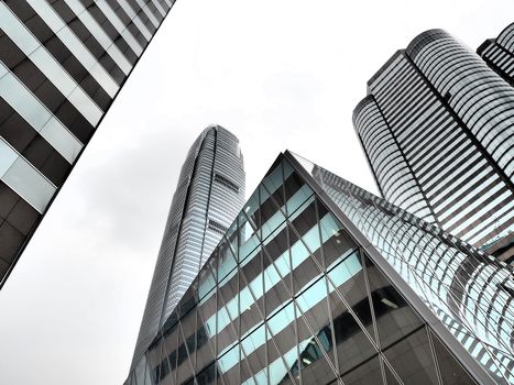 Striking modern architecture of Hong Kong's iconic skyscrapers under cloudy skies.