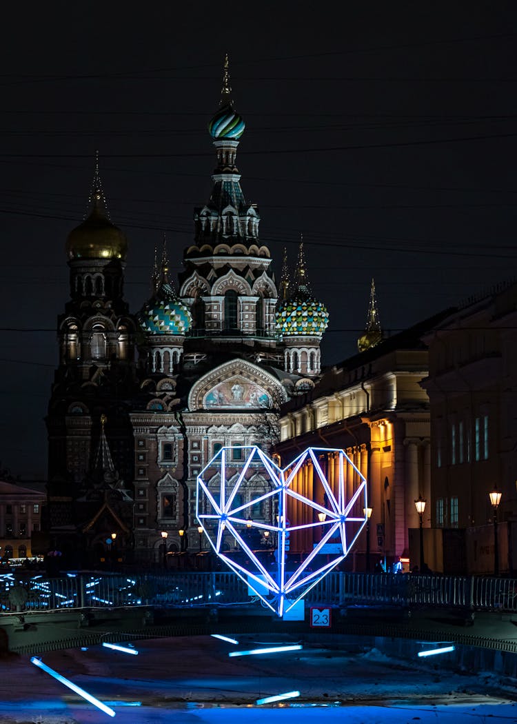 Heart Shaped Neon Lights With Church In Background By Night