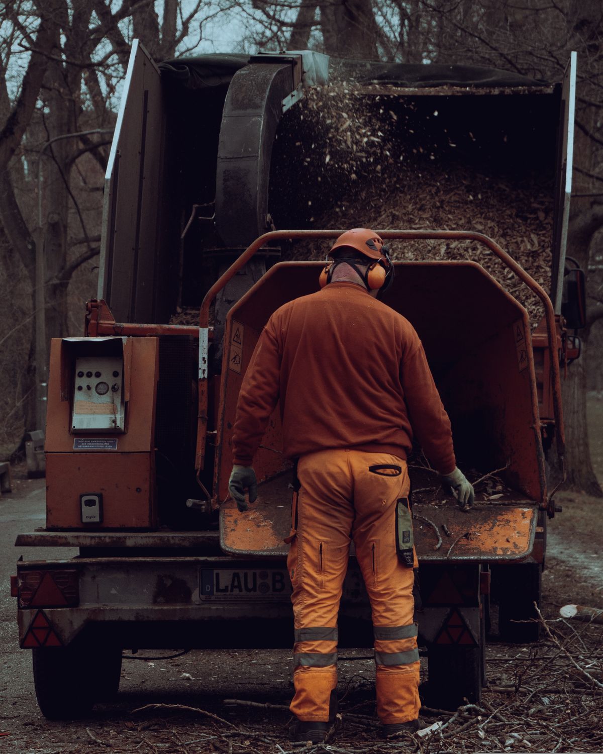Tree service crew operating wood chipper for debris removal in Miramar FL