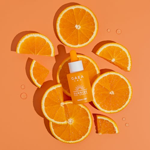 Bottle with a Cosmetic Product on the Background of Oranges 