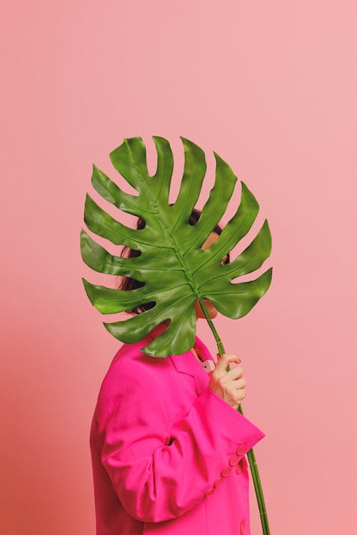 Woman in Pink Blazer Holding a Leaf