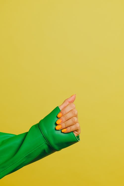 무료 노란색 배경, 녹색 자켓, 매니큐어의 무료 스톡 사진