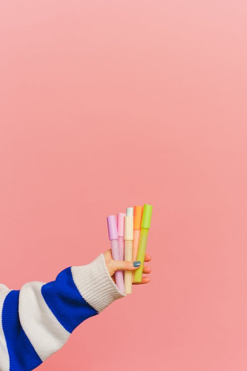 Gratis stockfoto met gekleurde markeringen, handen, roze achtergrond Stockfoto