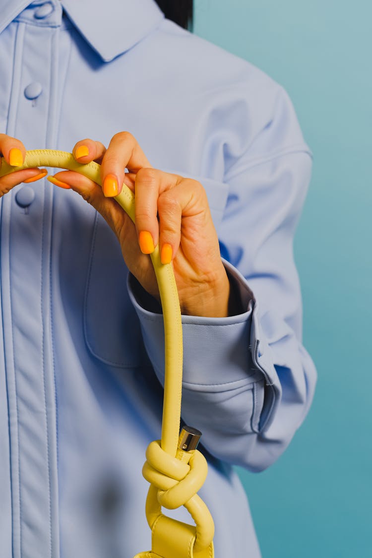 Woman In A Blue Long Sleeve Shirt Holding A Yellow Cable