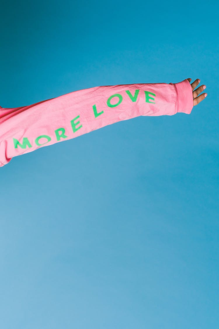 Arm Of A Person In Pink Long Sleeves In Light Blue Background