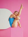 Teenage Girl Sitting in Gymnastic Position on Pink Block