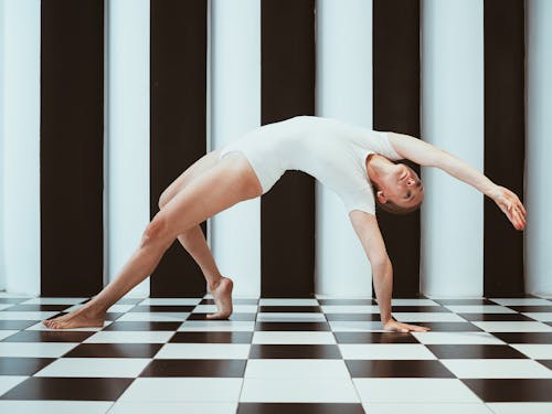 Woman in White Costume in Bridge Gymnastic Position